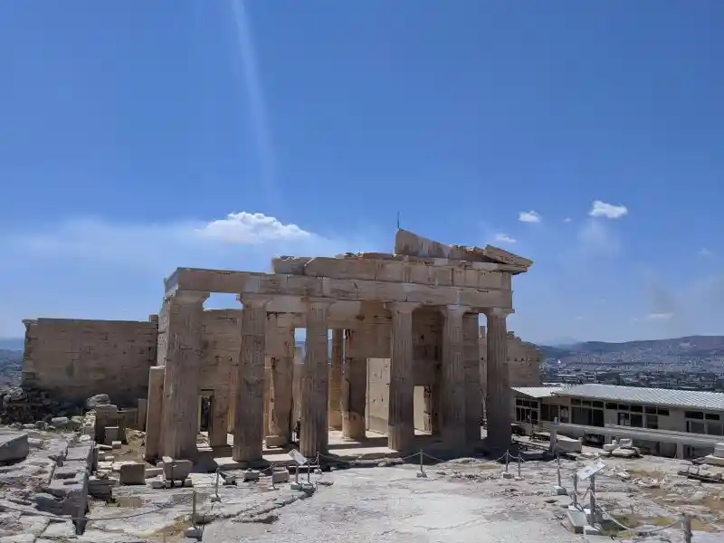 Gateway to the Acropolis framed by Doric columns and panoramic Athens skyline